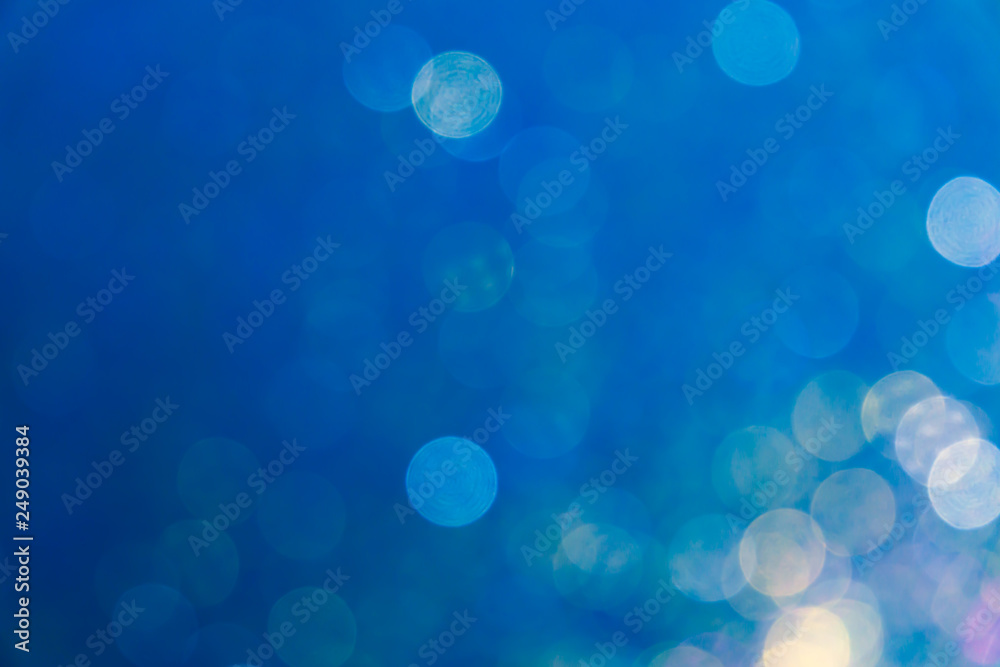 Blue bokeh background, abstract defocused lights.