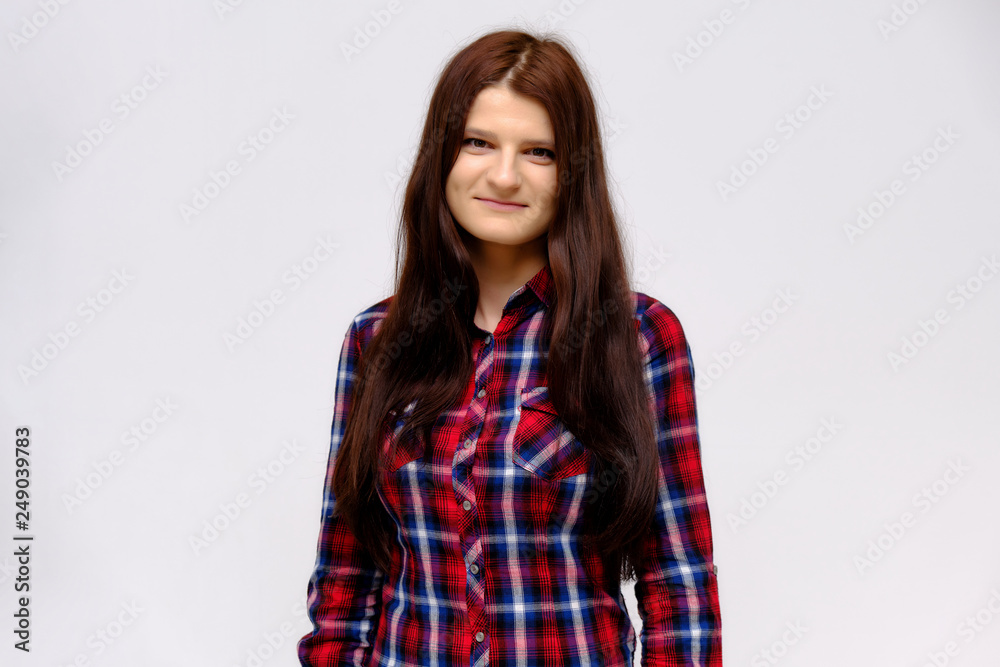 Concept studio portrait of a beautiful young beautiful brunette girl on a white background with different emotions in a multi-colored shirt. Concept studio portrait of a beautiful young beautiful brunette girl on a white background with different emotions in a multi-colored shirt.