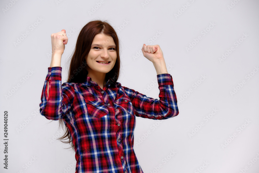 Concept studio portrait of a beautiful young beautiful brunette girl on a white background with different emotions in a multi-colored shirt. Concept studio portrait of a beautiful young beautiful brunette girl on a white background with different emotions in a multi-colored shirt.