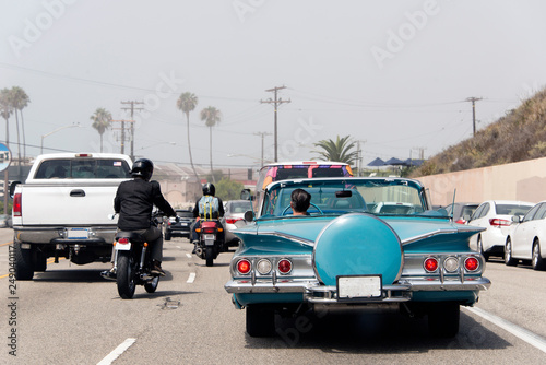 A traffic jam in Malibu, California with a vintage convertible car, motorcycle and pick up truck in summer time