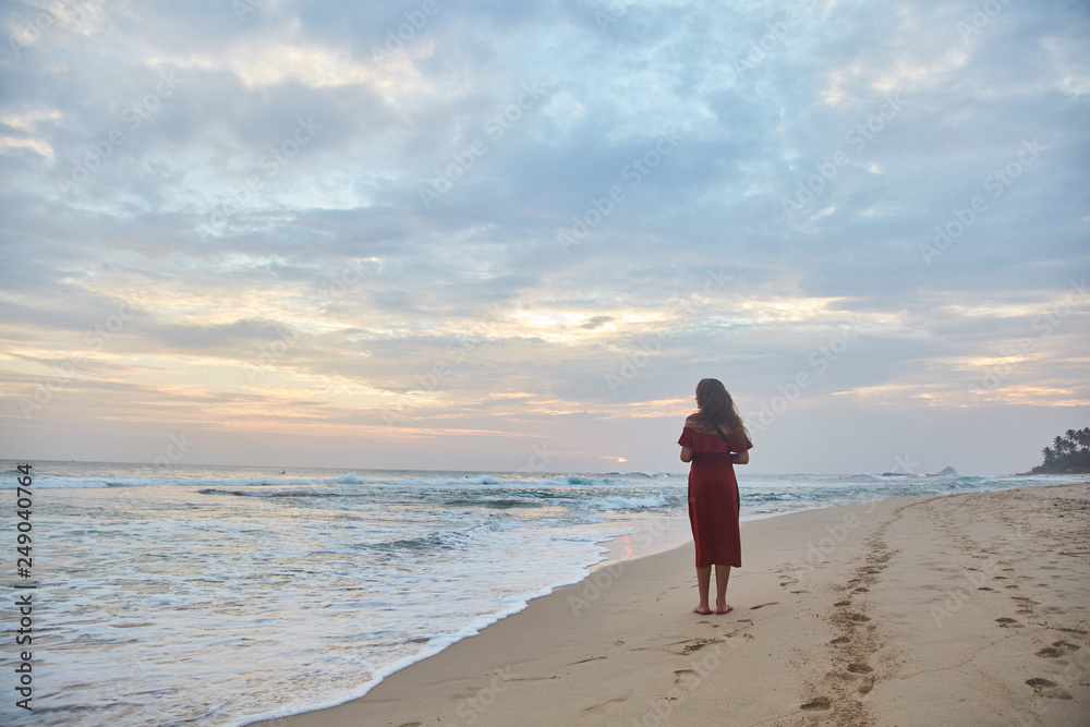 Young girl walking along the beach.