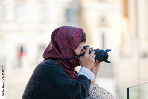 Femme avec un fourlard rouge sur la tête prenant une photo photo