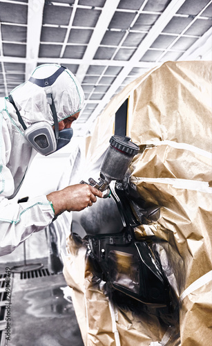 Painting the car in black color in the paint chamber on the service..