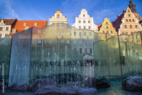 Wroclaw, Poland. Famous fountain on the Market Square and colourful historical buildings against the blue sky.