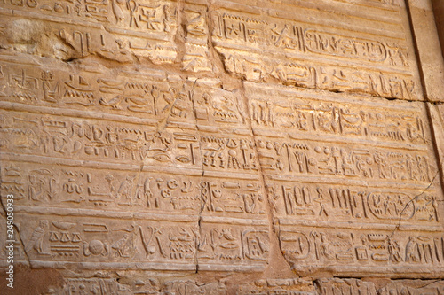 Egyptian hieroglyphs, symbols and signs on a stone wall in Karnak temple. Bass-relief.