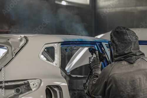 Employee car body painting shop carries out painting of the internal elements of the car