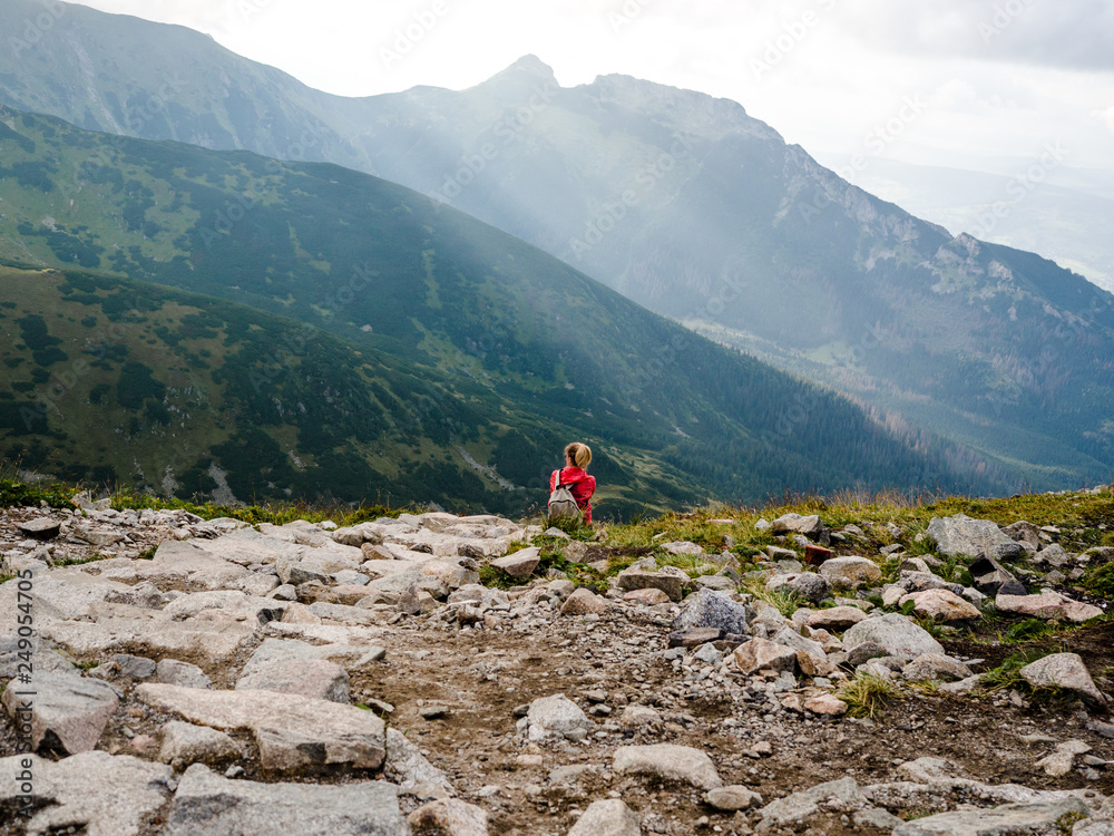 Girl on the top of Tatras Mountains far away in Poland and Slovakia, View of a girl hiking to Slovakian mountains high alone in summer.