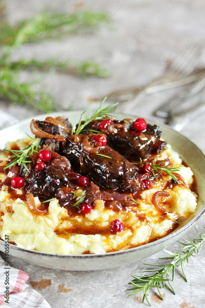 braised beef ribs with cranberries, onions and rosemary. served with mashed potatoes. braised beef ribs with cranberries, onions and rosemary. served with mashed potatoes.