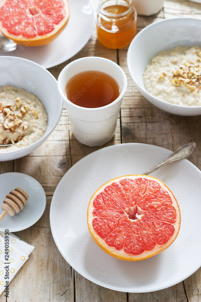 Vegetarian breakfast for two of oatmeal, baked grapefruit and tea. Rustic style. Vegetarian breakfast for two of oatmeal, baked grapefruit and tea. Rustic style.