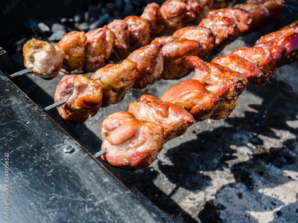 Barbecue skewers meat kebabs with vegetables on flaming grill, Grilled kebab cooking on metal skewers (grill). Roasted meat cooked at barbecue with smoke. Close up BBQ fresh pork meat chop slices.