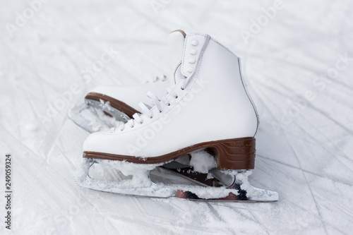 close up of figure skates over ice with marks from skating