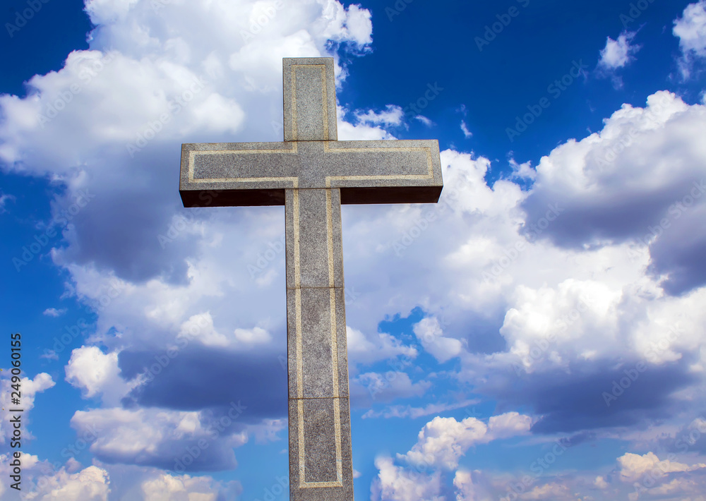 Stone Orthodox cross against a cloudy sky