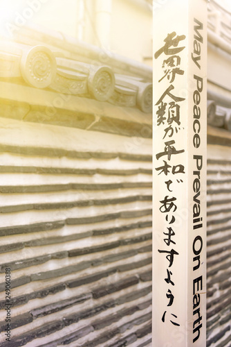 Famous sentence 'May Peace Prevail On Earth' by Byakko Shinkokai Sect's creator Goi Masahisa inscribed on a Peace Pole Project's pole planted by WPPS The World Peace Prayer Society. photo