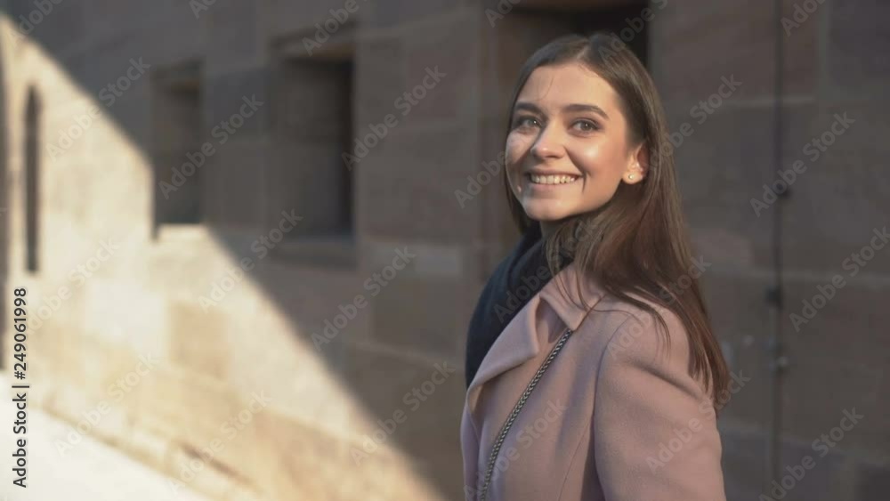 Young attractive woman enjoying walk in native city, smiling and waving, home Young attractive woman enjoying walk in native city, smiling and waving, home