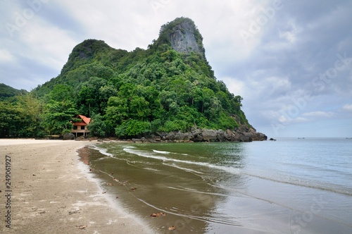 A beach with white sand and rocky limestone cliff at Pathio District of Chumphon province of Thailand