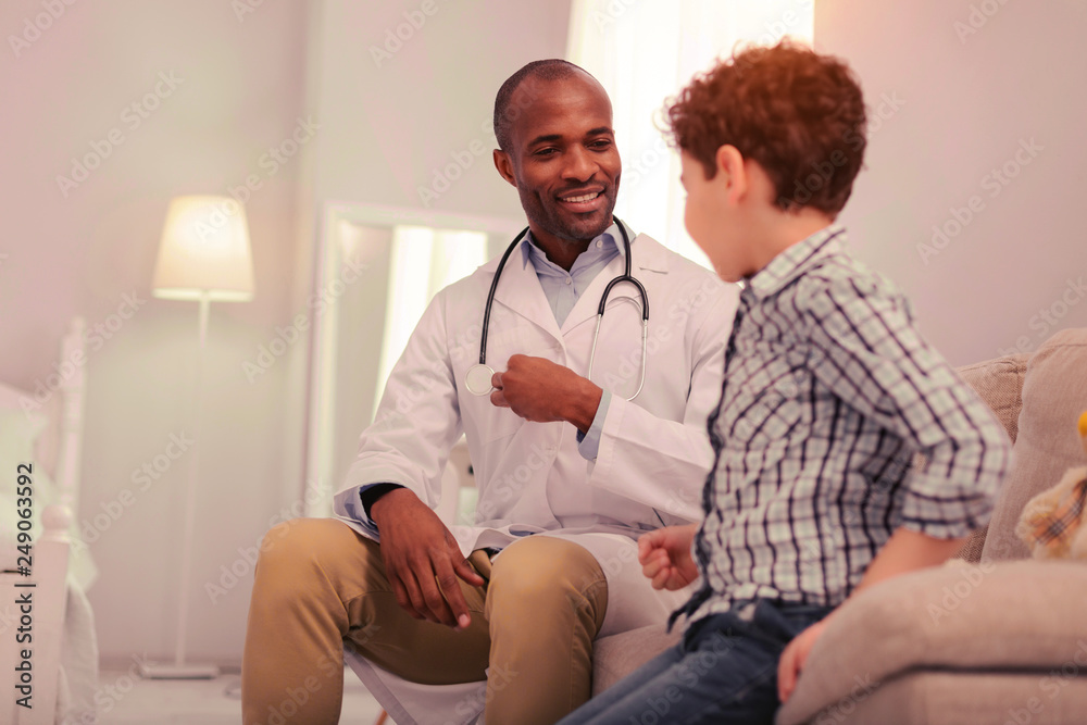 Doctor explaining the process of examination to his young patient Doctor explaining the process of examination to his young patient