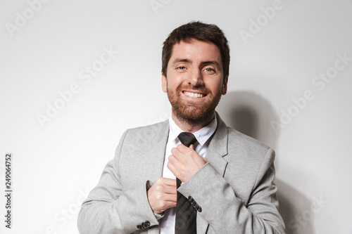 Handsome young businessman in formal clothes isolated over white wall background.