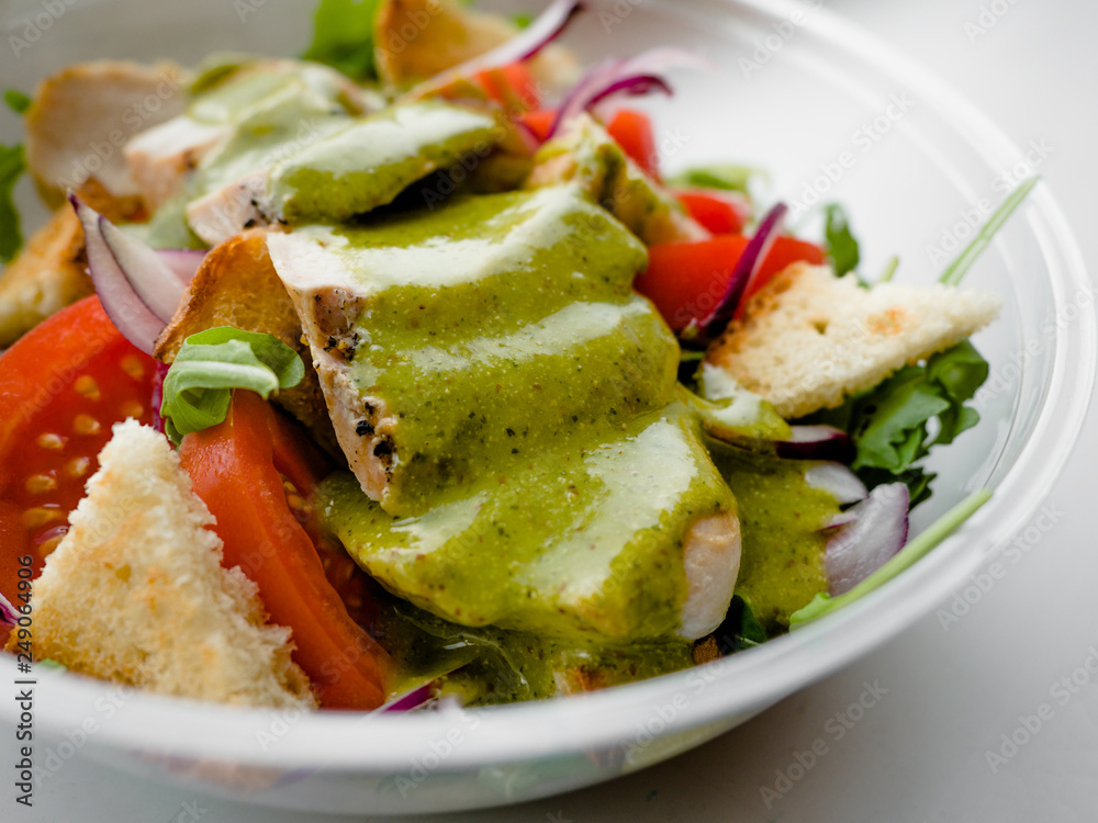 Healthy simple Chicken salad with tomatoes, arugula, green salad dressing and bread croutons in the a glass bowl, Vinaigrette For Green Salad Recipe. Healthy simple Chicken salad with tomatoes, arugula, green salad dressing and bread croutons in the a glass bowl, Vinaigrette For Green Salad Recipe.