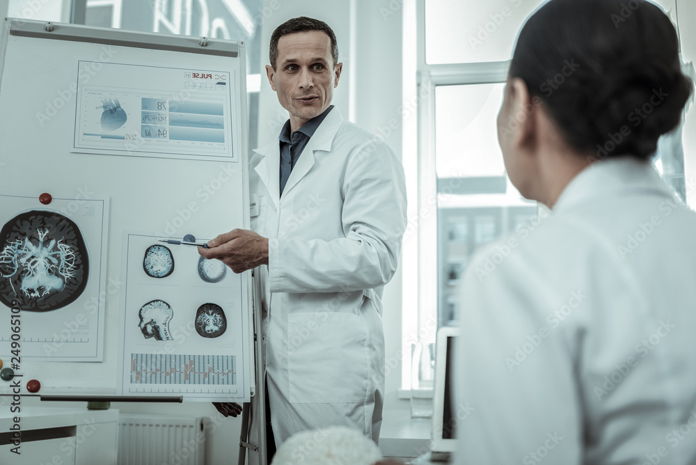 Professional male medical specialist pointing on MRI photo Professional male medical specialist pointing on MRI photo