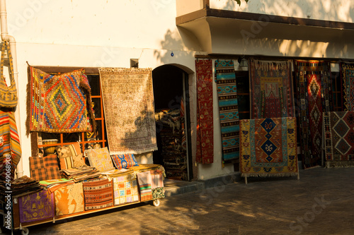 Colourful Handmade Carpets Displayed on the Street.The ancient building with souvenir shop n old Turkish town photo