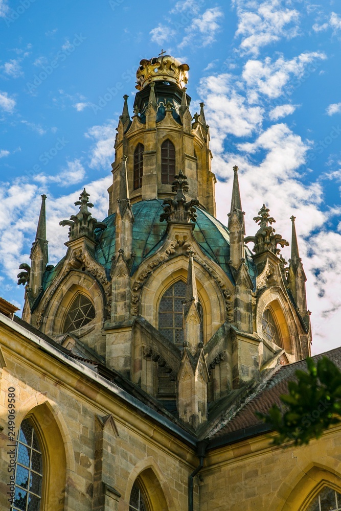 Kladruby, Czech Republic / Europe - July 7 2018: Yellow dome of church of the Assumption of the Virgin Mary built in baroque gothic style, golden crown on top, sunny summer day, blue sky with clouds