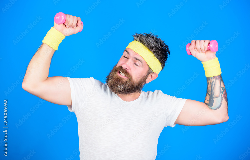 Athlete training with tiny dumbbell. Motivated athlete guy. Sportsman training with dumbbells blue background. Improve your muscles. Man bearded athlete exercising dumbbell. Use weights or dumbbells Athlete training with tiny dumbbell. Motivated athlete guy. Sportsman training with dumbbells blue background. Improve your muscles. Man bearded athlete exercising dumbbell. Use weights or dumbbells