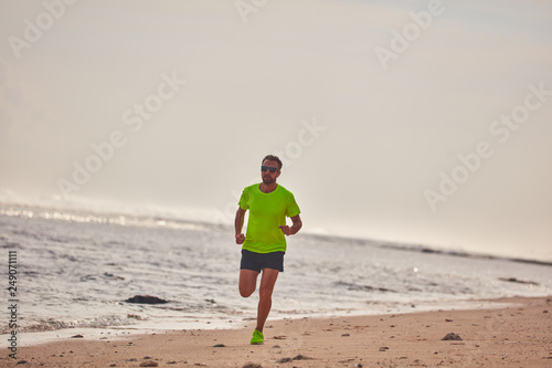 Man running / jogging on a tropical exotic beach.