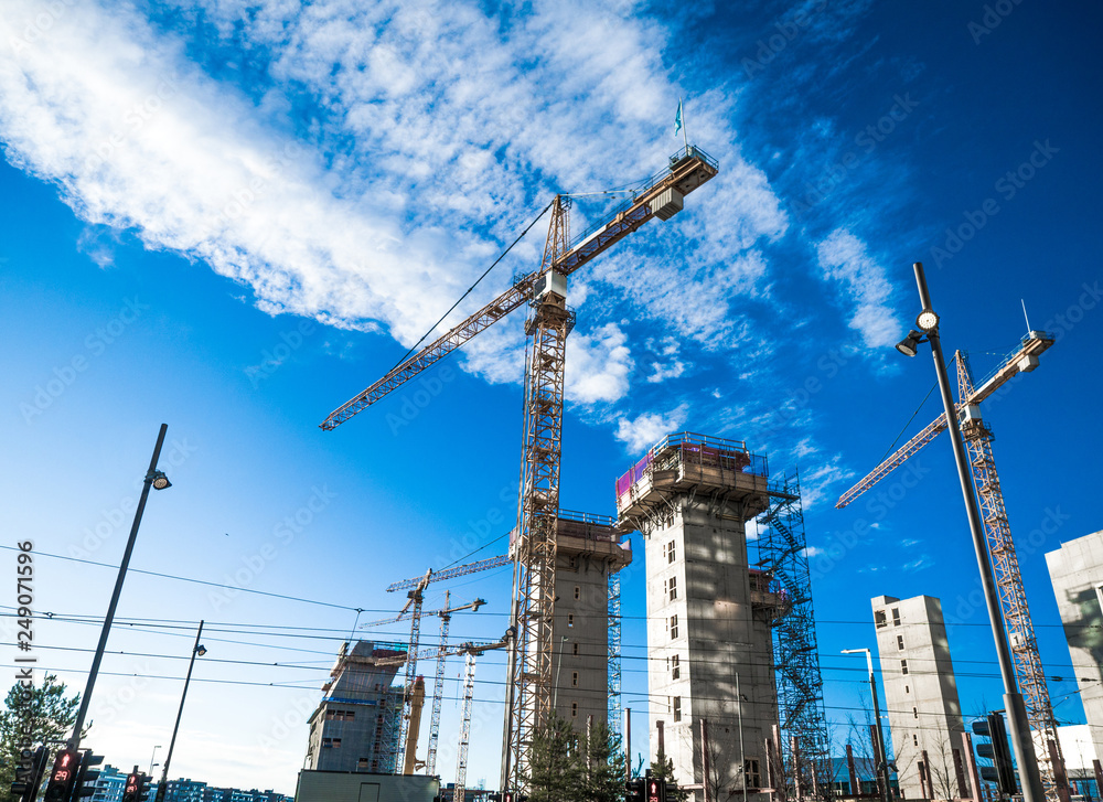 One of the high rise apartment building site under industry construction concept with cranes against blue sky. One of the high rise apartment building site under industry construction concept with cranes against blue sky.
