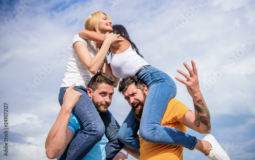 Friendship of families. Couples in love having fun. Men carry girlfriends on shoulders. Summer vacation and fun. Couples on double date. Inviting another couple to join. Twice fun on double date © be free