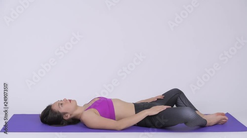 Young beautiful multi-ethnic woman doing Constructive Rest yoga pose