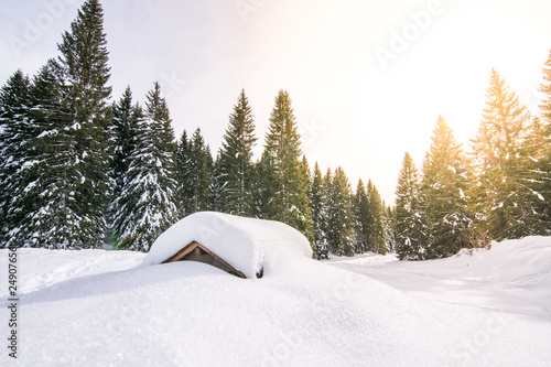 Baita di montagna ricoperta dalla neve e baciata dal sole. Foto scattata sulle Alpi nell'altopiano di Asiago