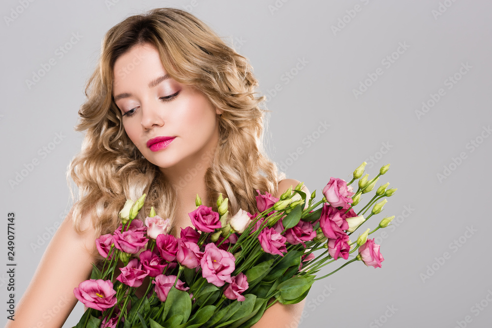 attractive woman with bouquet of Eustoma flowers isolated on grey