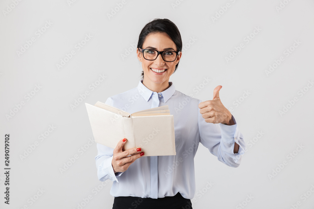 Photo of adorable female worker wearing eyeglasses reading book in the office, isolated over white background Photo of adorable female worker wearing eyeglasses reading book in the office, isolated over white background