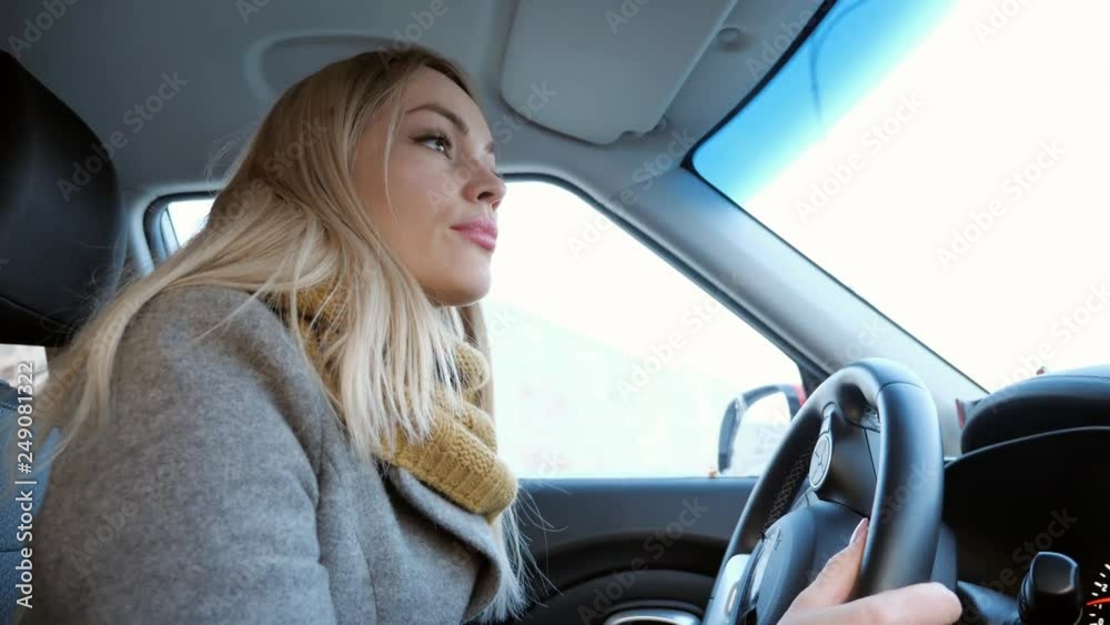 Young blonde girl driving car in in the daytime, close up Young blonde girl driving car in in the daytime, close up