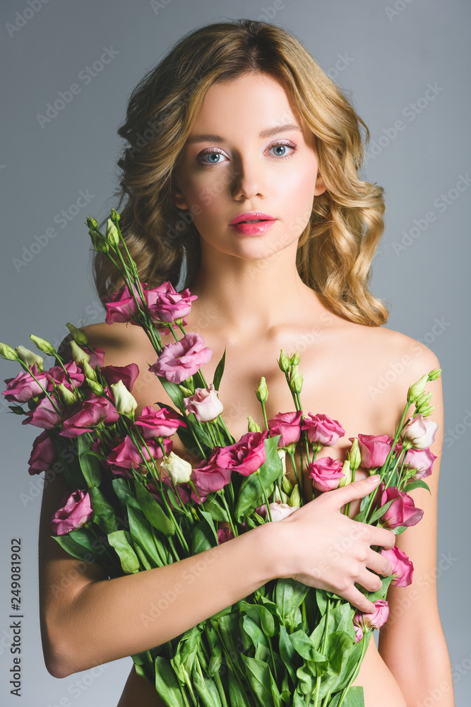 elegant naked woman holding bouquet of flowers isolated on grey