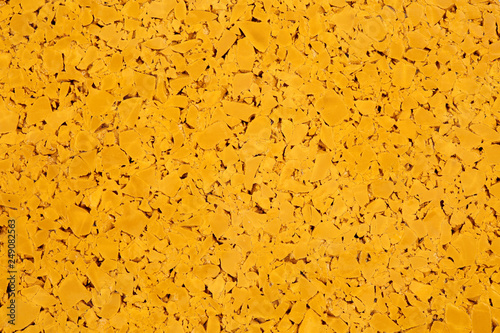 Dark yellow colored rubber floor background texture. Shock absorbent flooring for gyms, playgrounds, sports and running tracks