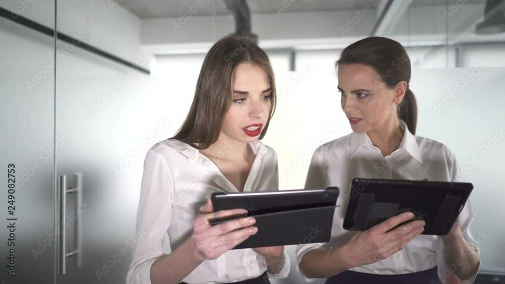 4К. Two pretty business woman in office with tablet discuss. Steady shot 4К. Two pretty business woman in office with tablet discuss. Steady shot