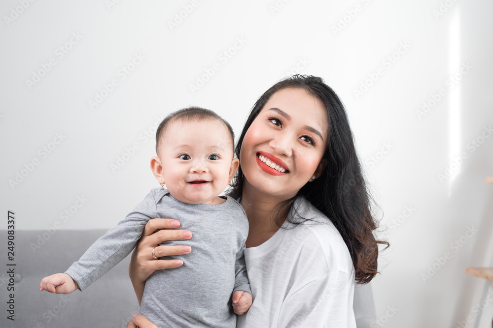 happy family at home. Mother holding baby daughter in living room in cozy weekend morning happy family at home. Mother holding baby daughter in living room in cozy weekend morning