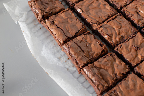 Chocolate brownies on a paper sheet on a metal rack