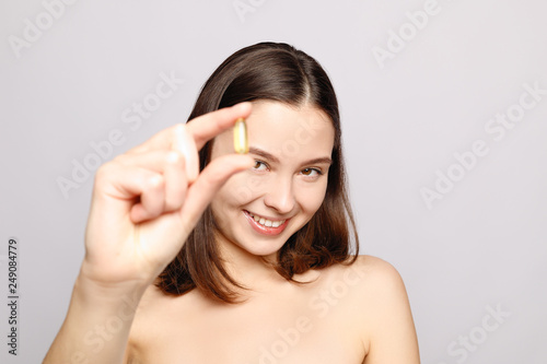 Healthy Diet Nutrition. Beautiful Smiling Young Woman Holding Fish Oil Pill In Hand. Closeup Of Happy Girl Taking Capsule With Cod Liver Oil, Omega-3. Vitamin And Dietary Supplements. High Resolution