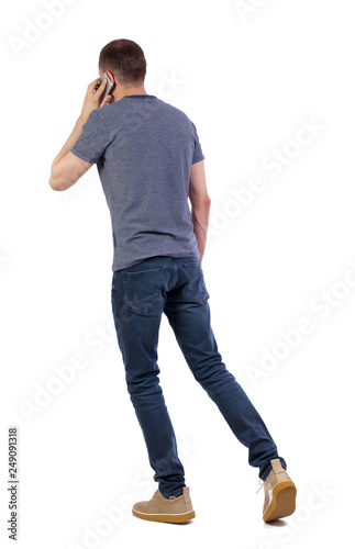 a side view of man walking with a mobile phone.