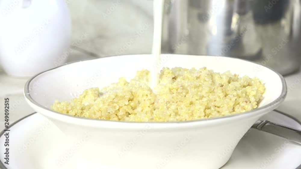 Pouring white quinoa seed into a measuring cup Pouring white quinoa seed into a measuring cup