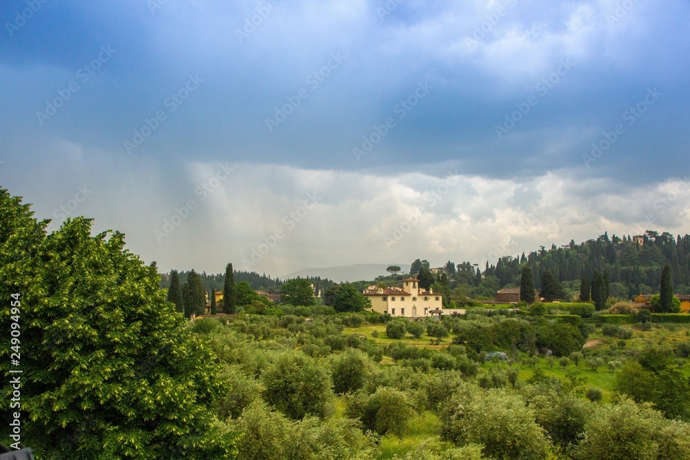Beautiful view of the Tuscany fields from the top of the hill at Boboli Garden. Rainy cloudy clouds over the beautiful Tuscan landscape. Florence, Italy.