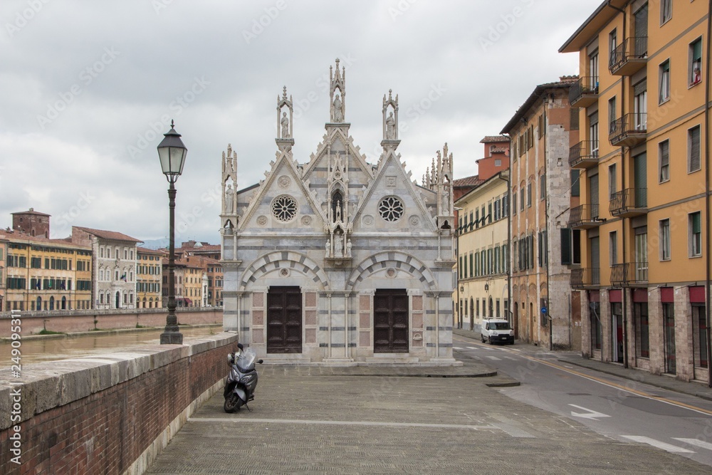 Small gothic church Santa Maria della Spina near the river Arno in Pisa, Italy. Cloudy, rainy weather. Pisa, Italy.