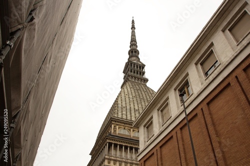 Mole Antonelliana tower in Turin (Torino) town. Rainy, cloudy weather. Tower view from below. Beautiful geometric building. Geometry in buildings. Architecture Of Turin, Italy.