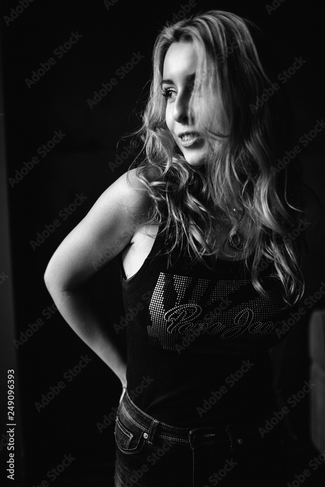 Fototapeta premium Portrait of a beautiful fashionable woman, blonde, jeans, brown background