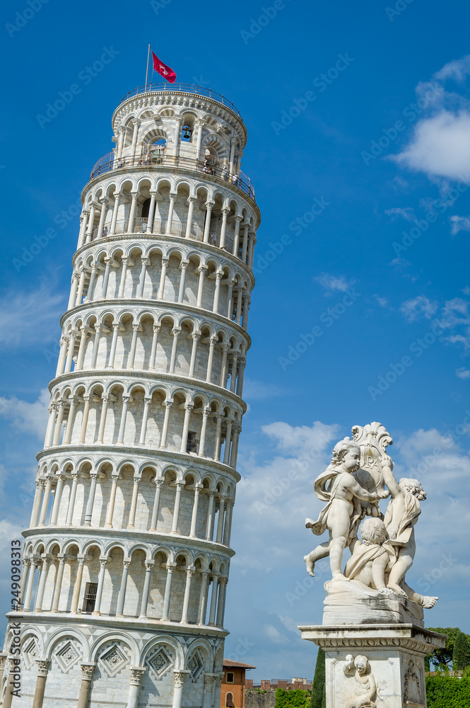 Vertical photo of famous Pisa Tower and Putti Fountain sculpture. Toscana travel attractions, Italy.