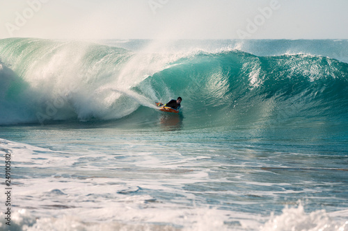 Fotografia surfer riding the tube of a wave with a bodyboard