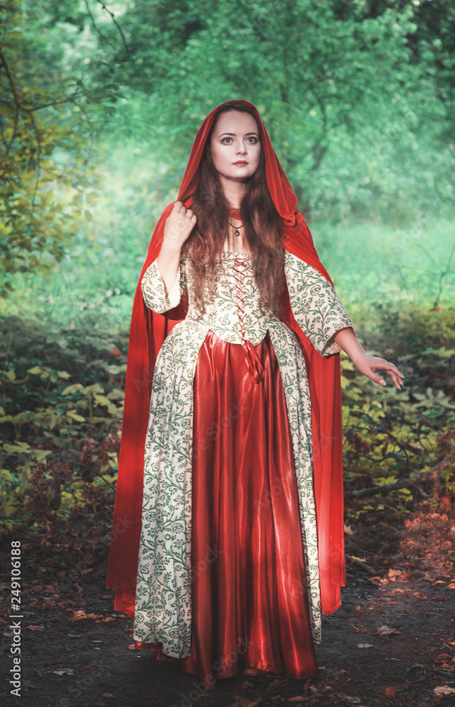 Beautiful woman in medieval dress and red cloak Beautiful woman in medieval dress and red cloak