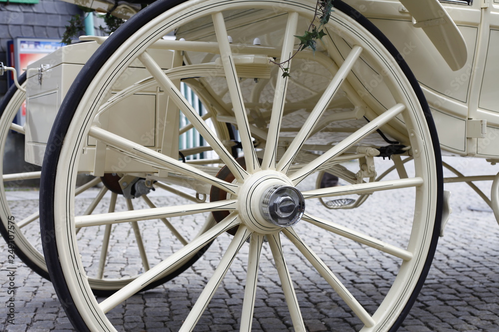 old wagon wheel of white wedding carriage